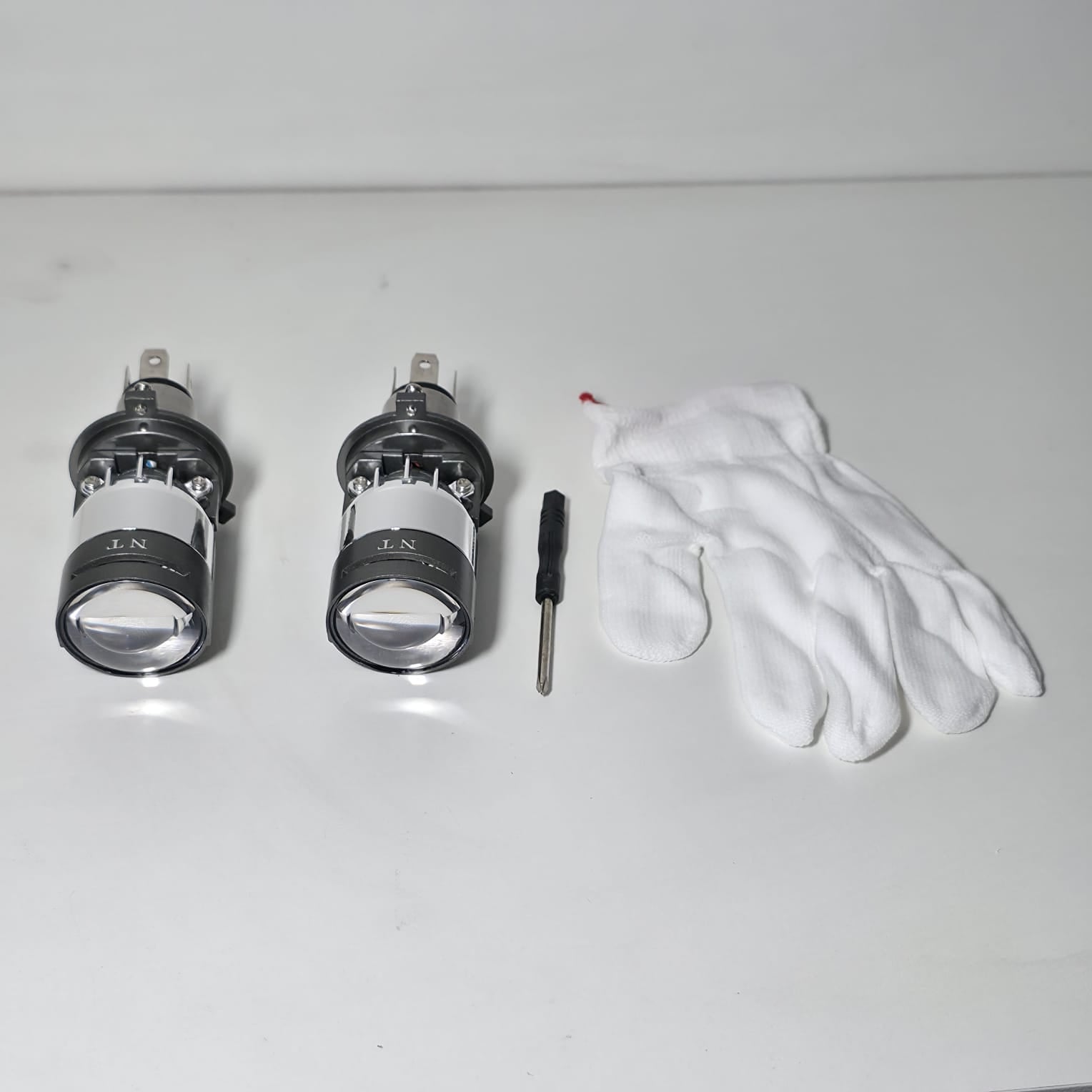 Accesorios completos del kit Bi-LED proyector H4 incluyendo focos, guantes y destornillador de ajuste.