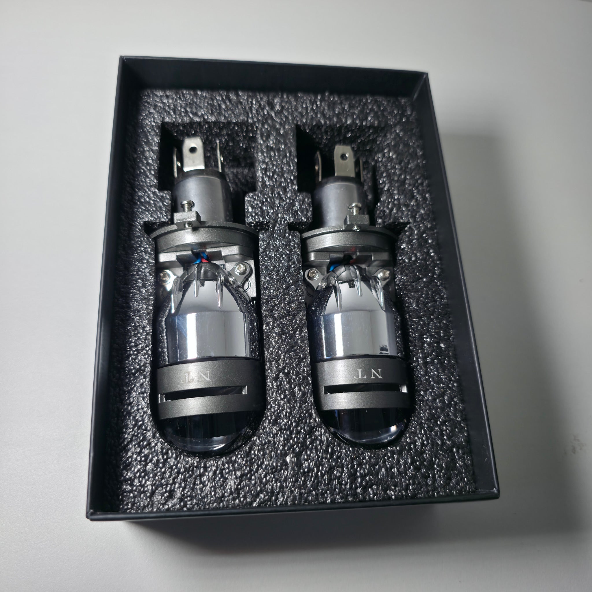 Par de proyectores Bi-LED H4 acomodados en el interior de su empaque premium Nitro Max.