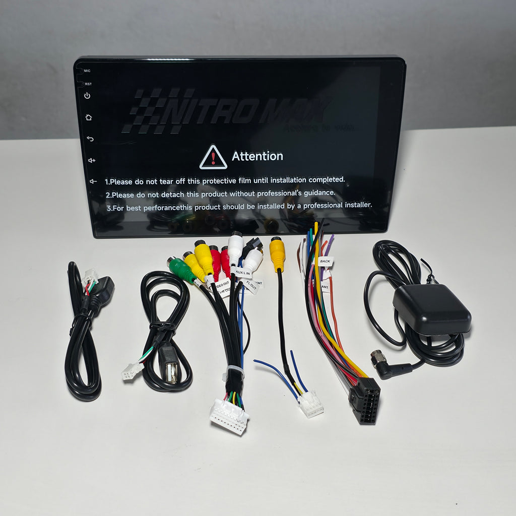 Radio Nitro Max 9 pulgadas 1 DIN y sus accesorios, incluidos cables, arnés y antena GPS, extendidos sobre una mesa.